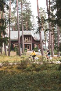 a group of people riding bikes in front of a house at LVM tūrisma un atpūtas centrs "Spāre" in Spāre