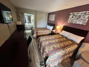 a hotel room with two beds and a couch at Southern Inn in Manchester