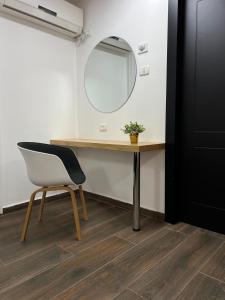 einen Schreibtisch mit einem Stuhl und einem Spiegel in der Unterkunft סוויטת Gadish in Bet Scheʼan