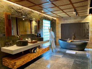 ein Badezimmer mit zwei Waschbecken und einer großen Badewanne in der Unterkunft Abian Ayu Villa in Sidemen