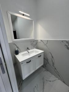 Baño blanco con lavabo y espejo en Villa Life en San Donato Milanese