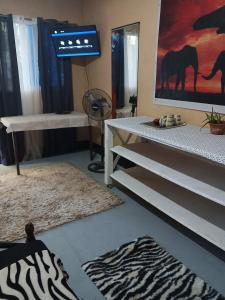 een kamer met een zebratapijt en een tv bij Two crazy monkeys in Bakjawan