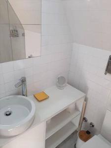 a white bathroom with a sink and a mirror at River & Beach Apartment near Lisbon in Trafaria