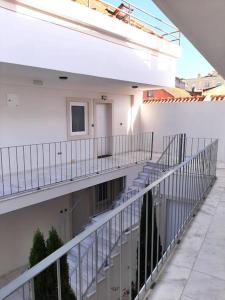 een balkon van een wit gebouw met een trap bij River & Beach Apartment near Lisbon in Trafaria