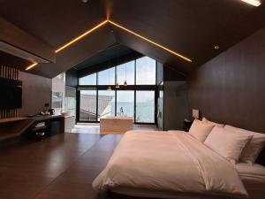 1 dormitorio con cama grande y ventana grande en Gyeongnam goseong Hotel With7, en Goseong