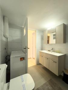 a white bathroom with a toilet and a sink at Gtrip Nea Smyrni Apartment - 3421 in Athens