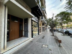 a building on a street with a bench in front at Gtrip Nea Smyrni Apartment - 3421 in Athens