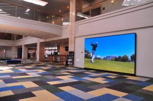 a large screen television in a lobby with a golfer on it at Satsuma Resort Hotel in Satsuma