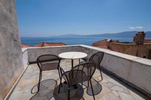 un patio con 2 sillas y una mesa en el balcón en Goulas Traditional Guesthouse, en Monemvasia
