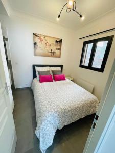 - une chambre avec un lit et 2 oreillers roses dans l'établissement Cocon 4 pers vue mer, à Menton 15 autres photos