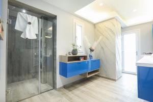 baño con ducha y armario azul en Ulivi Verdi Villa, en Kontokali