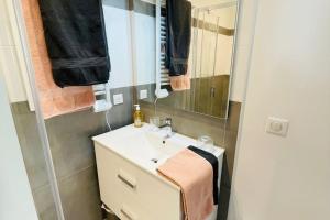 une salle de bain avec un lavabo et un miroir dans l'établissement Cocon 4 pers vue mer, à Menton