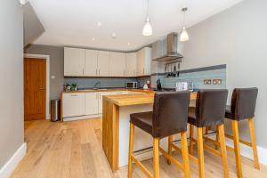 a kitchen with a wooden counter and chairs in it at Fantastic Multilevel 3BR, Vibrant Angel, 5min Tube in London