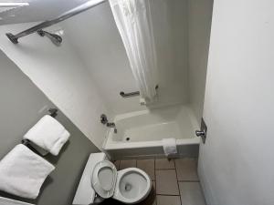 a bathroom with a toilet and a bath tub at Southern Inn in Manchester