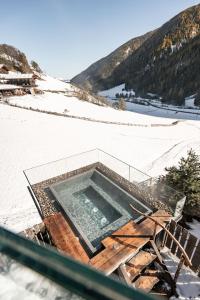 a swimming pool on top of a snow covered slope at Hotel Waltershof in Ultimo