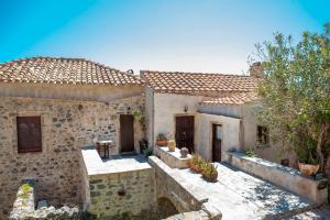 an old stone house with a patio in the yard at Goulas Traditional Guesthouse in Monemvasia