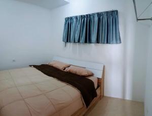 a bed in a room with a blue curtain at 2-Bedroom Condo with City Skyline View in Vientiane