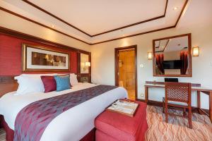 Habitación de hotel con cama grande y espejo en Nairobi Serena Hotel, en Nairobi