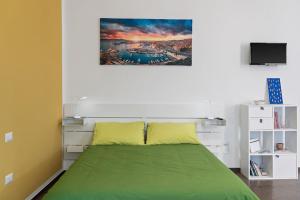 um quarto com uma cama verde e uma televisão em HomeToLove Marina em Cagliari