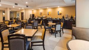 a restaurant with tables and chairs and a bar at Best Western Plus - Columbia North East in Columbia