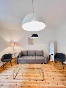 a living room with a couch and two chairs at Central City Cosy Lux in Berlin