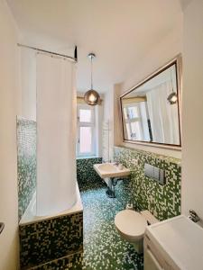 a bathroom with a toilet and a sink and a shower at Central City Cosy Lux in Berlin