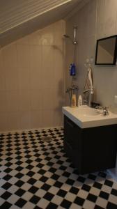 a bathroom with a sink and a black and white checkered floor at Pehtoorin Kammarit in Iltasmäki +15 photos