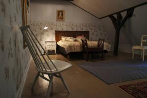 a bedroom with a bed and a chair and a table at Pehtoorin Kammarit in Iltasmäki