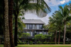 三亞的住宿－三亚安隅酒店，前面有棕榈树的房子