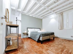 1 dormitorio blanco con 1 cama y suelo de madera en [Centro] ModenaCharme: la Porta sul Centro en Módena