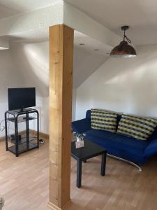 a living room with a blue couch and a tv at kuscheliges Marburg in Marburg an der Lahn