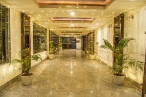 um corredor com vasos de plantas num edifício em Parnil Palace em Guwahati