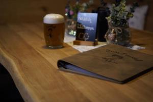a book on a table with a glass of beer at Ferienwohnung zum Lausbub in Eckersdorf