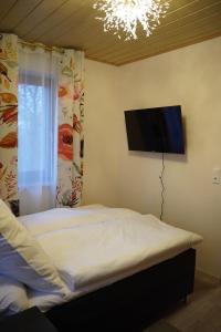 a bedroom with a bed and a flat screen tv at Ferienwohnung zum Lausbub in Eckersdorf
