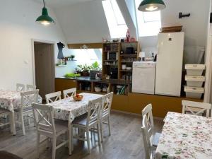 a kitchen with tables and chairs and a refrigerator at Esztergom Central in Esztergom
