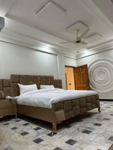 a bedroom with a large bed and a ceiling at Hotel Flower of Capital in Islamabad