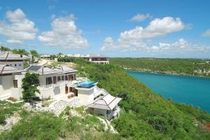 una vista aérea de una casa en una colina junto al agua en Stunning 3 bedroom villa with Pool & Jacuzzi, en Gaynors