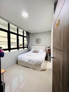 um quarto com uma cama branca e uma porta em Luna hotel em Ban Ko