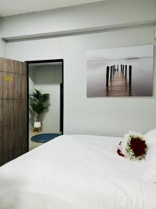 Ban KoにあるLuna hotelの白いベッドと壁に絵画が飾られたベッドルーム1室