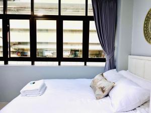 ein weißes Bett in einem Zimmer mit Fenster in der Unterkunft Luna hotel in Ban Ko