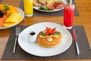 a table with two plates of pancakes with fruit on it at Villa Mia Seminyak - Boutique Villas in Seminyak