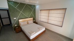 a small bedroom with a bed and a window at Jungle Drive Resort Vayalada in Kozhikode