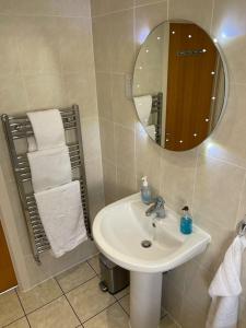 a bathroom with a sink and a mirror and towels at Home in Portishead