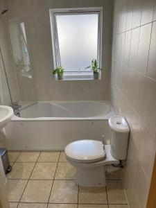 a bathroom with a toilet and a tub and a sink at Home in Portishead