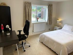 Schlafzimmer mit einem Bett, einem Schreibtisch und einem Stuhl in der Unterkunft Home in Portishead