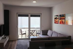 uma sala de estar com um sofá e vista para o oceano em Apartment Prishtina 038 em Pristina