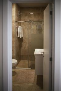 uma casa de banho com um chuveiro e um WC. em Apartment Prishtina 038 em Pristina