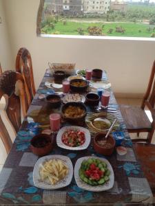 una mesa con muchos platos de comida. en Tasneem Palace, en Luxor