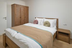 1 dormitorio con 1 cama grande y armario de madera en Sun Spalato Residence, en Makarska