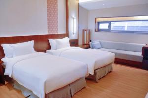 ein Hotelzimmer mit 2 Betten und einem Sofa in der Unterkunft Neodalle Zhangjiajie Wulingyuan in Zhangjiajie